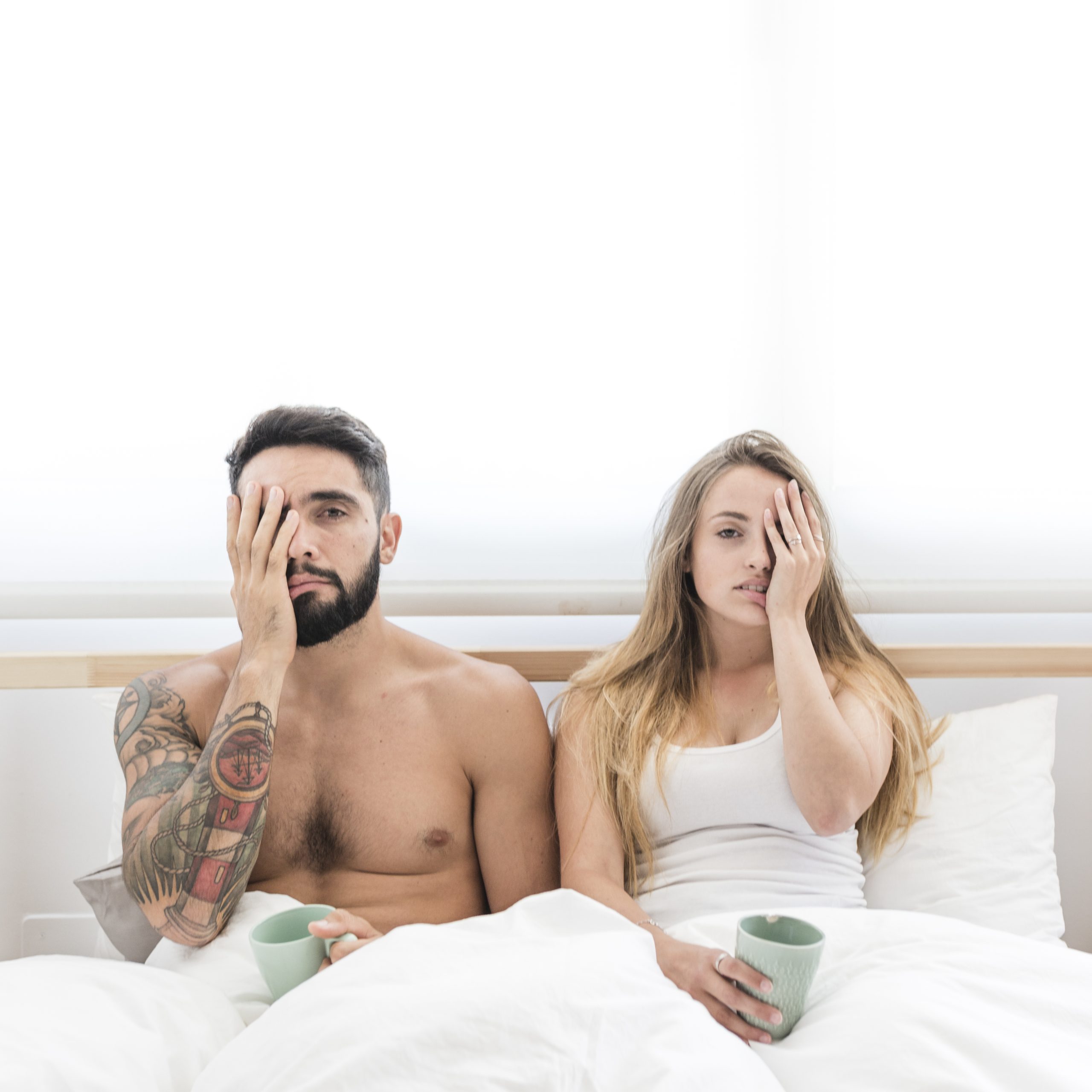 young-couple-sitting-bed-covering-their-one-eye